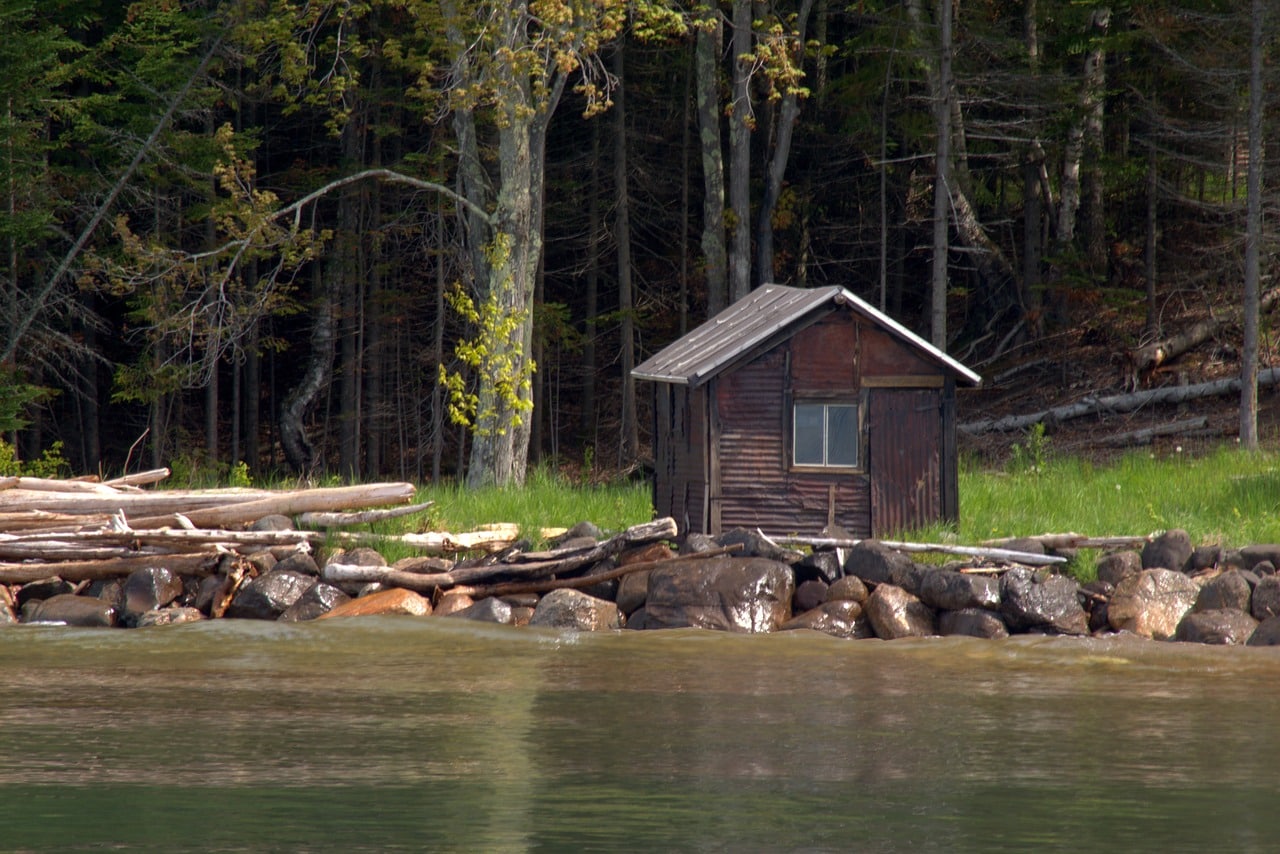 wooden cabin besides a river