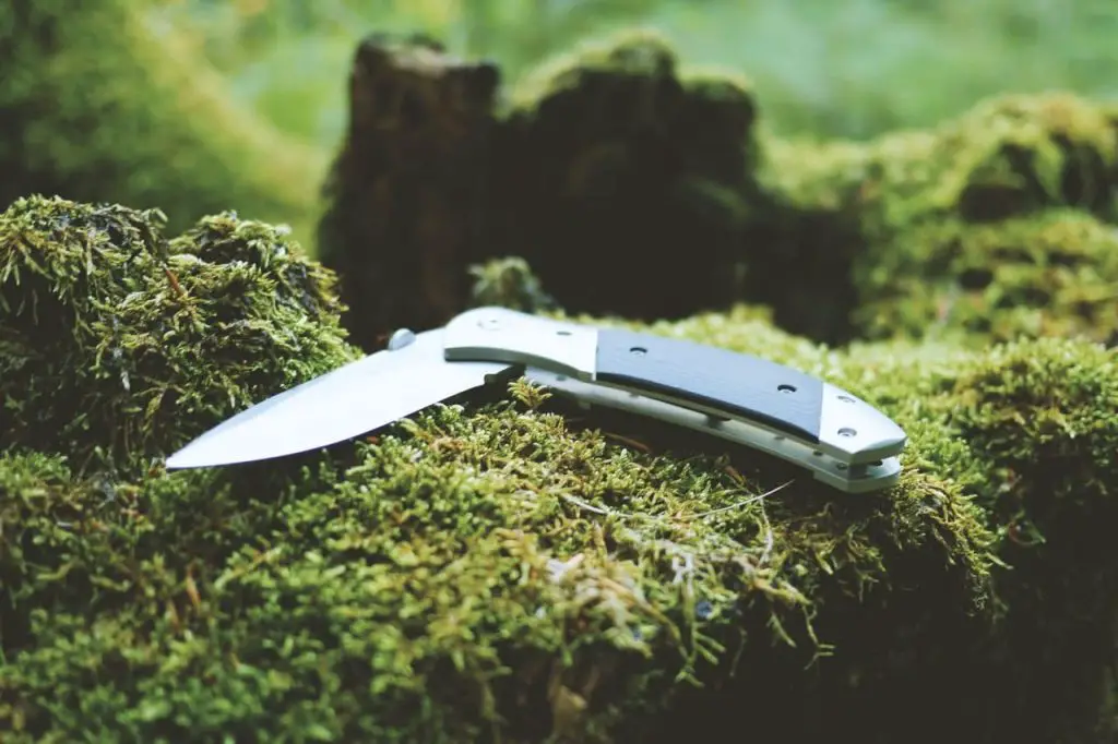 folding knife on a green grass in the wilderness